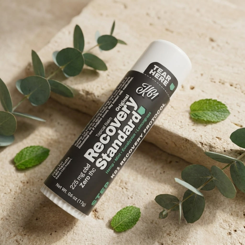 K61 Recovery Standard balm stick on cream stone with eucalyptus and mint, label showing 225 mg CBD and Zero THC