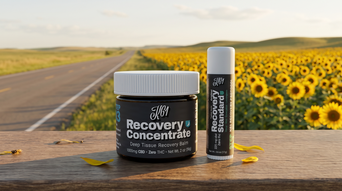 K61 Recovery Concentrate balm and Recovery Standard stick on a Kansas road beside a sunflower field