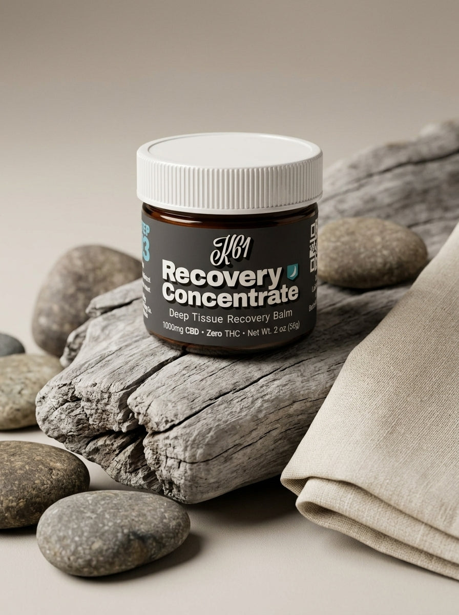 K61 Recovery Concentrate balm jar on river stones with natural linen