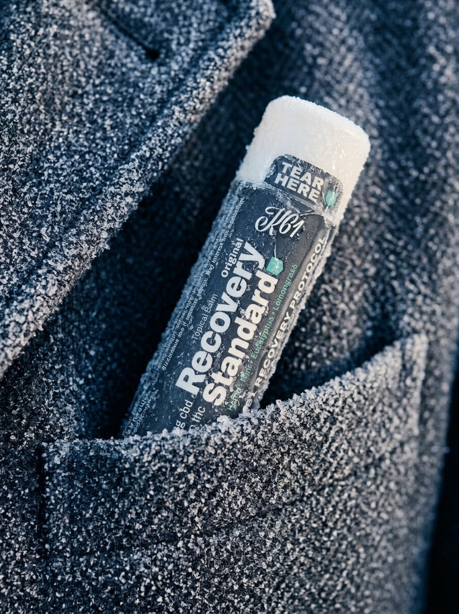 K61 Recovery Standard balm stick in the pocket of a frosted wool coat